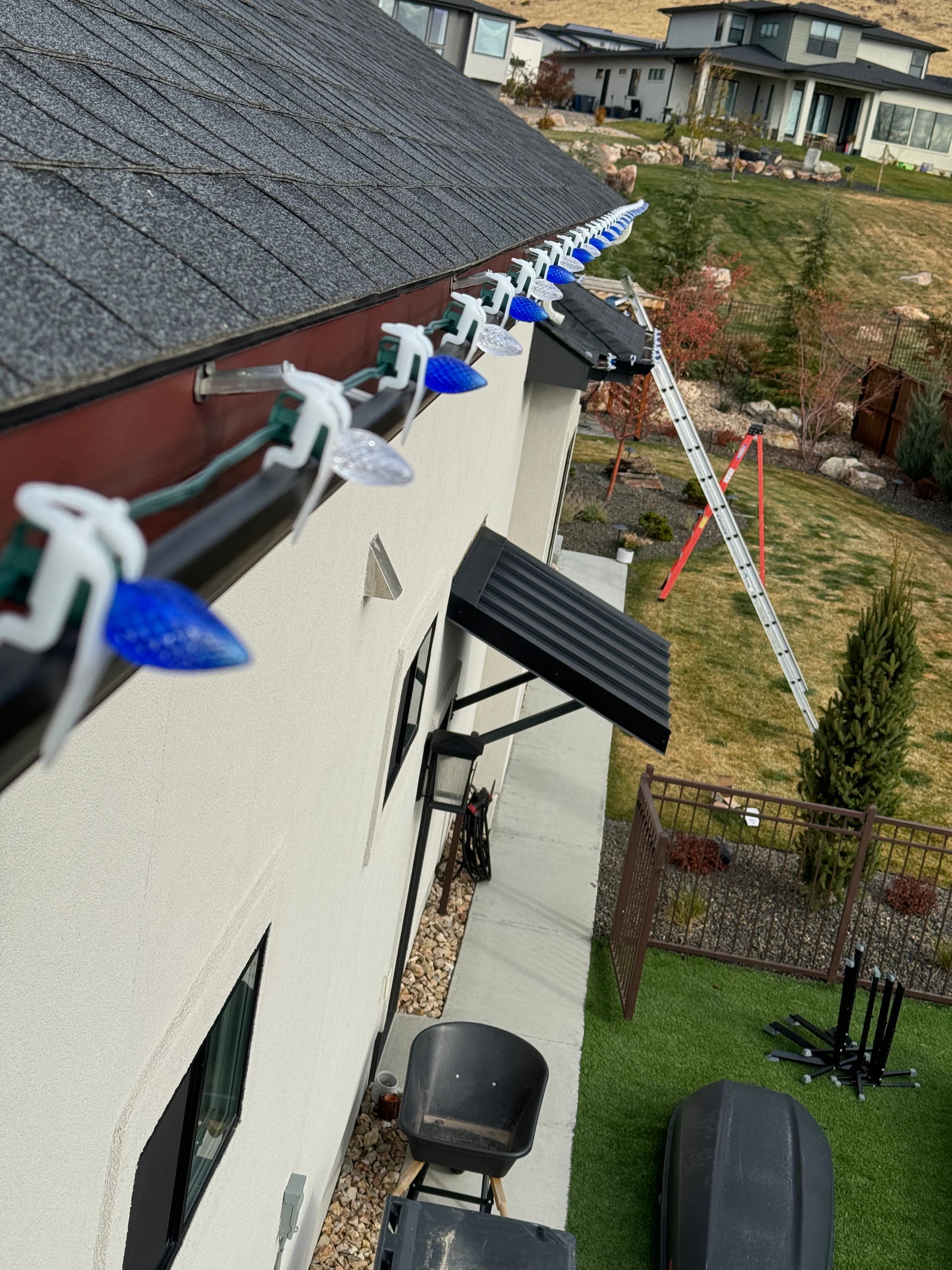 Blue and clear C9 Christmas lights installed along a gutter in Boise, ID by Christmas Light Installation Boise