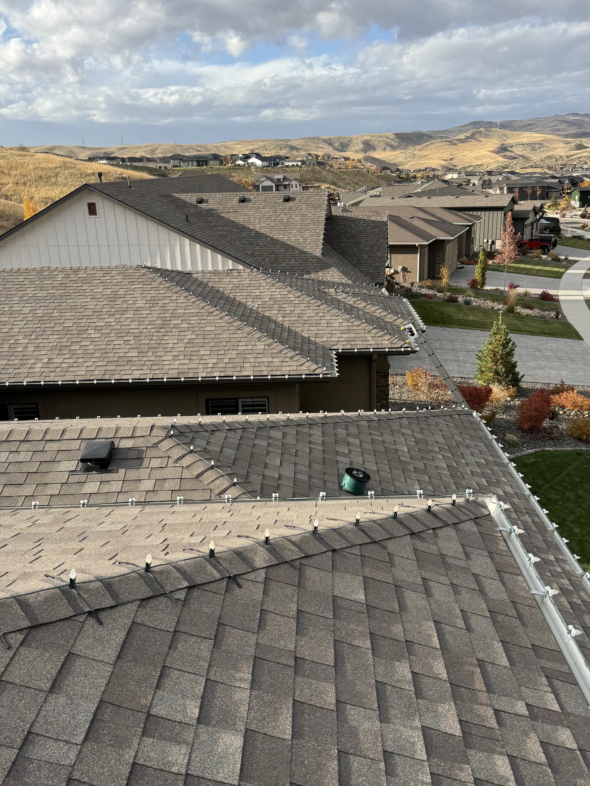 Professional roofline Christmas light install on hillside homes in Boise, ID by Christmas Light Installation Boise