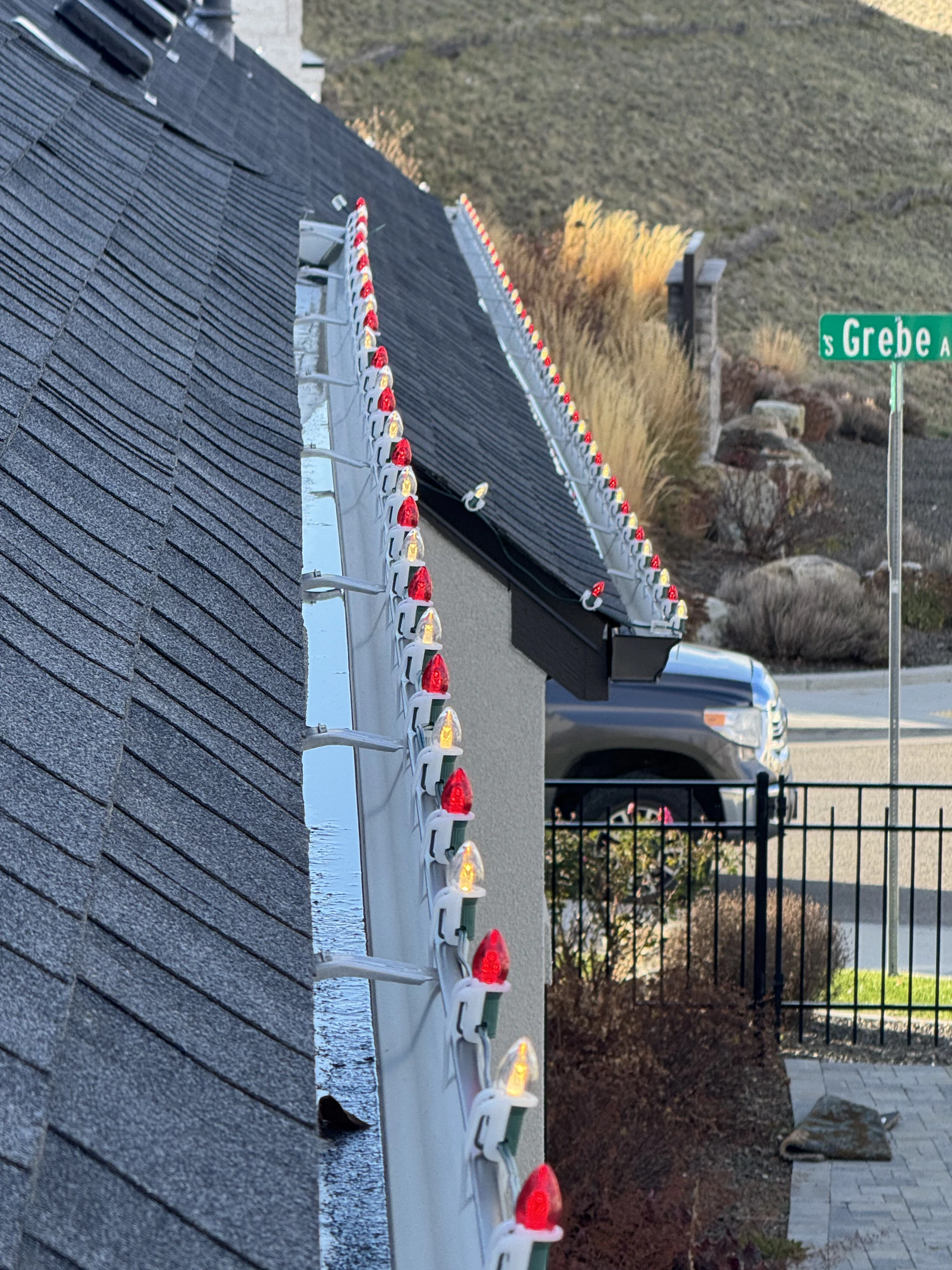 Red and gold C9 Christmas lights installed along a gutter line in Boise, ID by Christmas Light Installation Boise