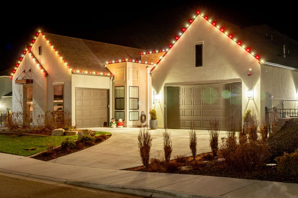 Red and warm-white peak Christmas lights on a home at night in Boise, ID by Christmas Light Installation Boise