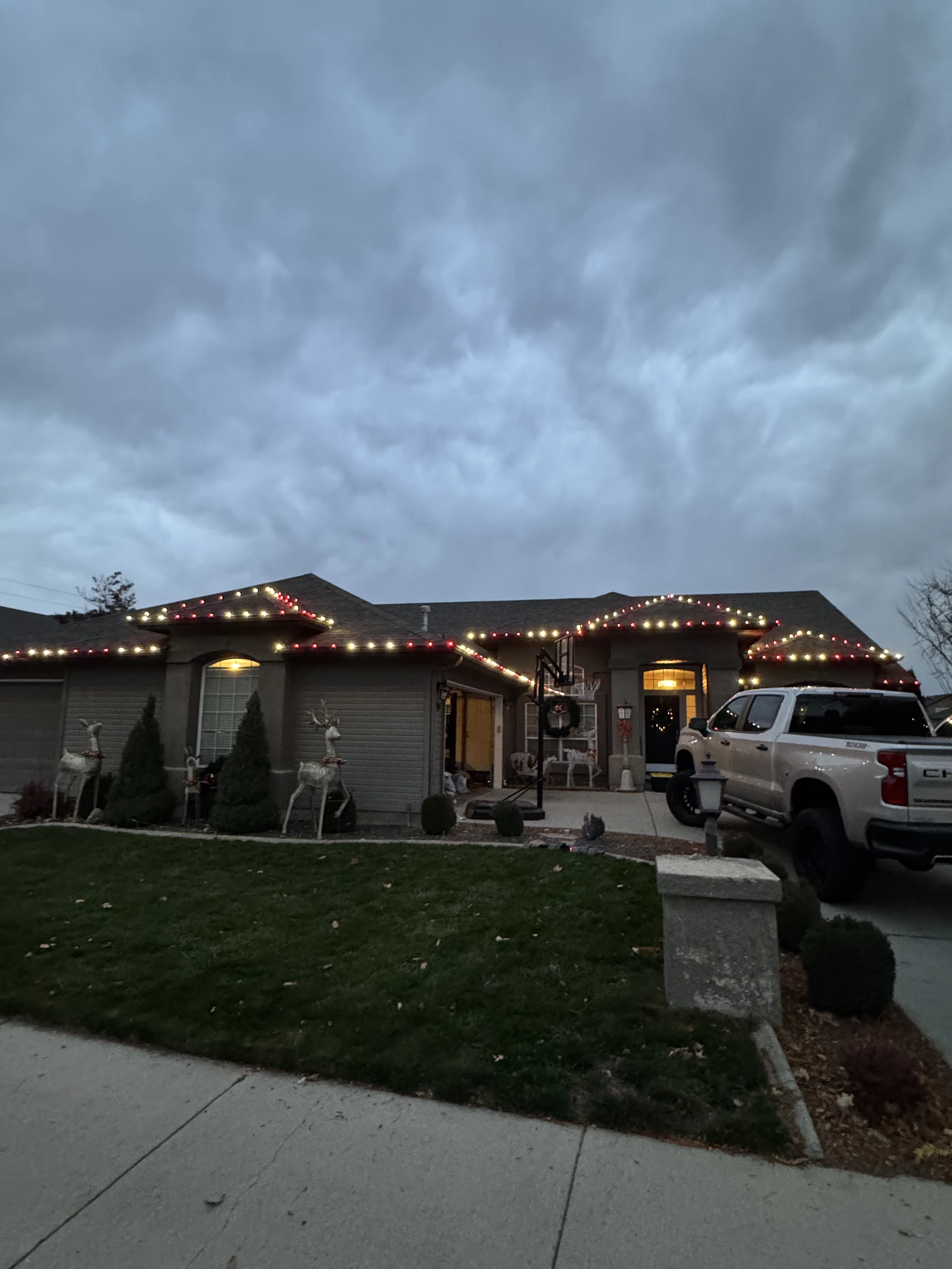 Red and warm-white roofline Christmas lights on a ranch home in Boise, ID by Christmas Light Installation Boise