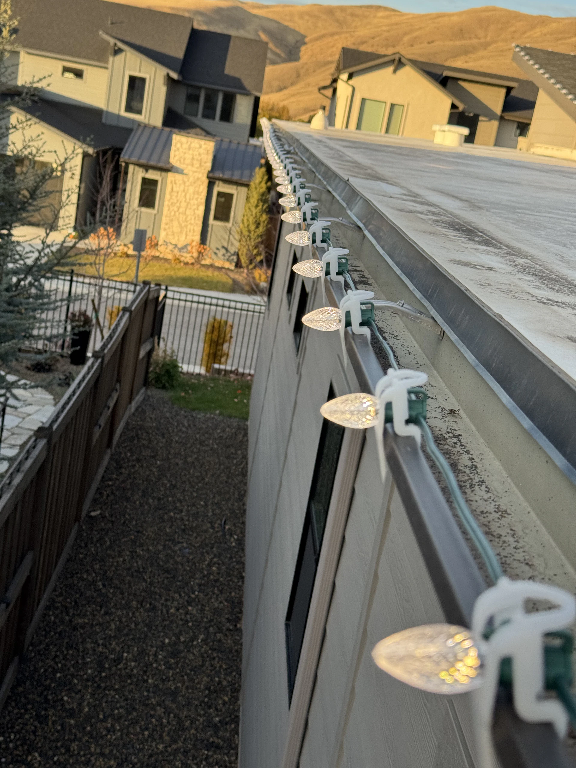 Warm white C9 Christmas lights clipped along a gutter edge in Boise, ID by Christmas Light Installation Boise