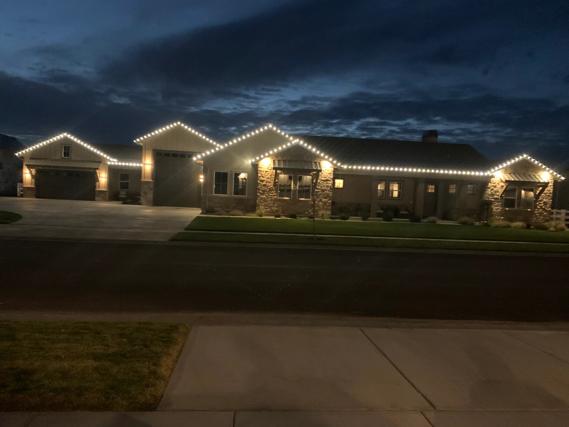 Warm white peak-to-peak Christmas lights on a ranch home at dusk in Boise, ID by Christmas Light Installation Boise