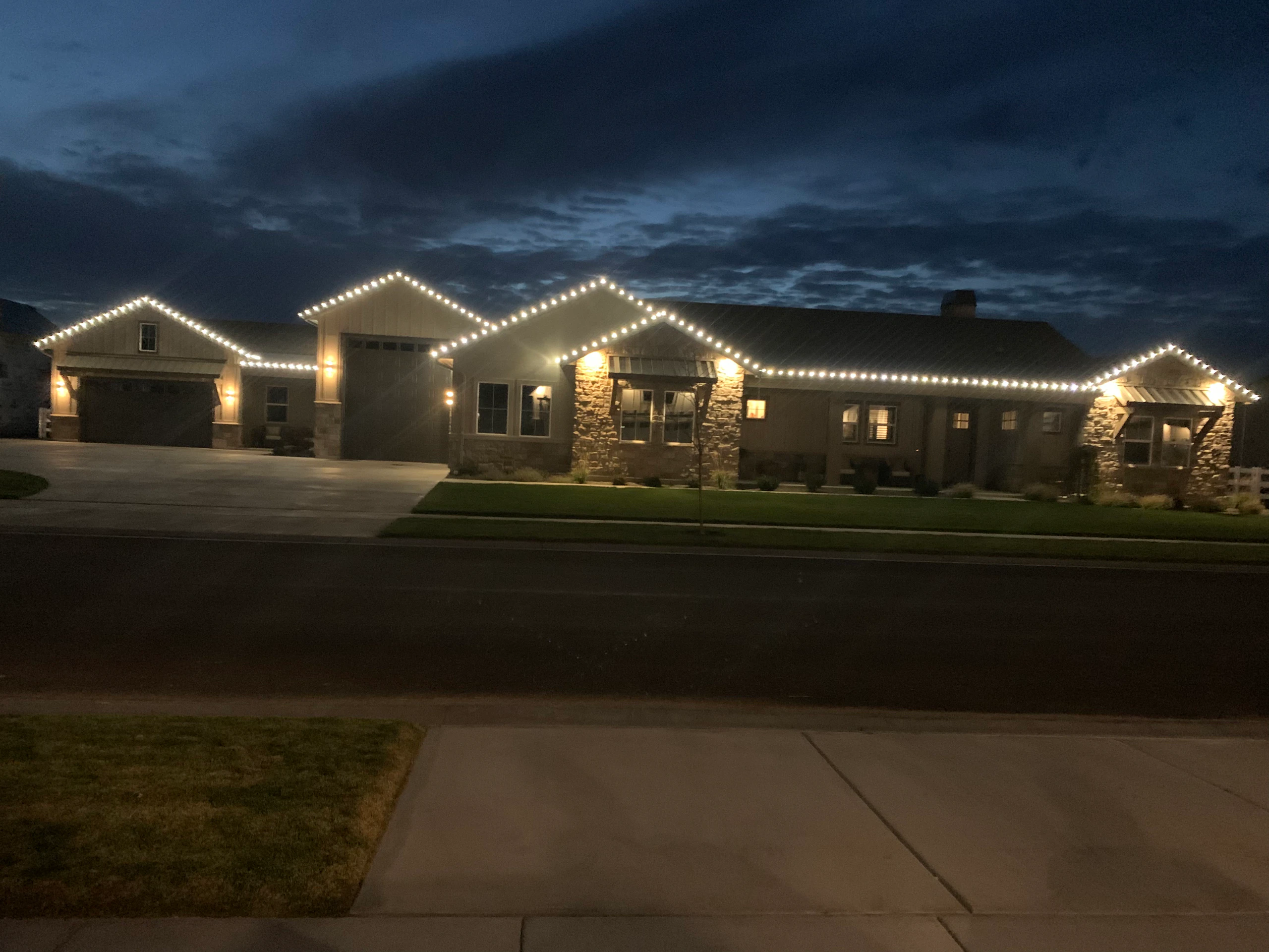 Warm white peak-to-peak Christmas lights on a ranch home at dusk in Boise, ID by Christmas Light Installation Boise