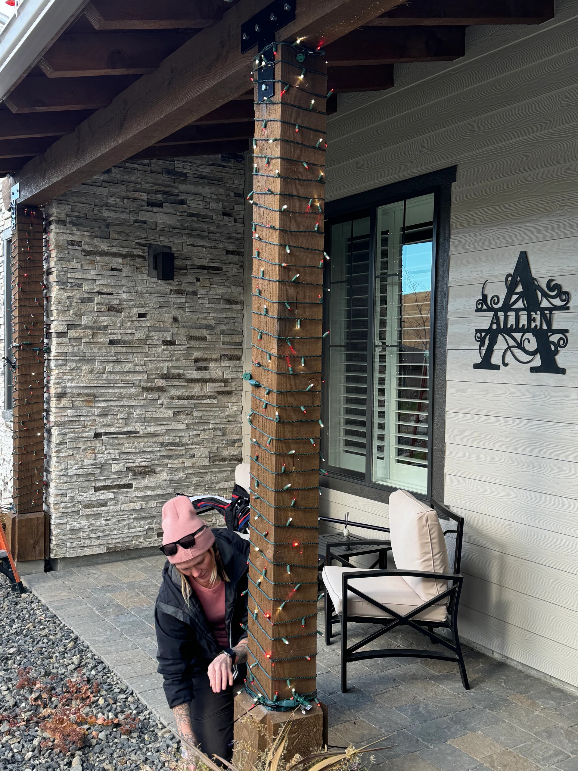 Wrapping a porch column with multicolor Christmas lights in Boise, ID by Christmas Light Installation Boise